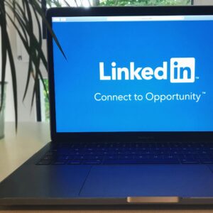 A laptop screen displaying the LinkedIn logo with the text 'Connect to Opportunity'.